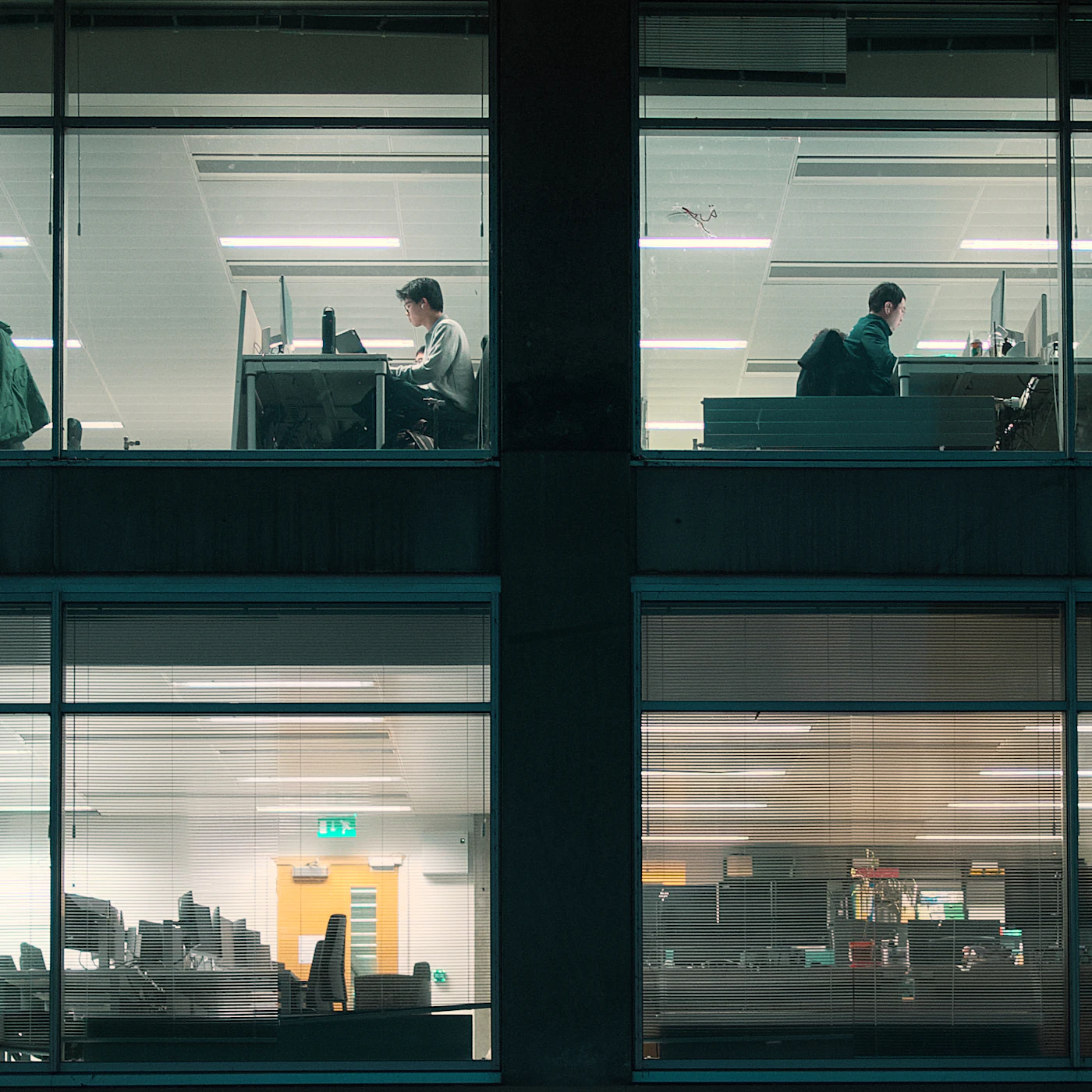 An office building at night, teams at work on every floor
